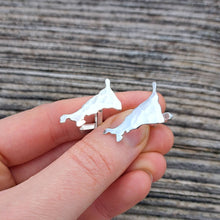 Load image into Gallery viewer, Hammered textured cornish cornwall map cufflinks, held in fingers against wood