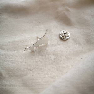 Cornish map silver  pin which brooch back on plain fabric
