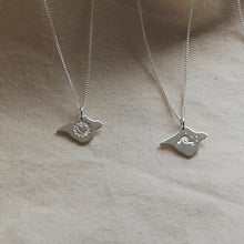 Load and play video in Gallery viewer, Video of four Isle of Wight shaped silver necklaces with different designs engraved - heart, wave, birds and texture