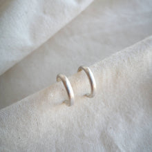 Load image into Gallery viewer, Silver hoops with brushed satin matte finish on calico fabric
