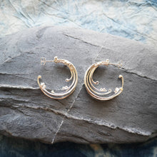 Load image into Gallery viewer, Recycled silver wild wave hoop earrings on grey stone