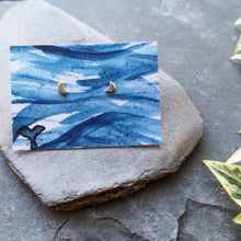 Load image into Gallery viewer, Half moon tiny eco silver studs on watercolour backing card of waves and a whale tail