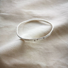 Load image into Gallery viewer, Sustainable recycled silver wave bangle, freefrom curves with silver balls for detail, on top of calico fabric