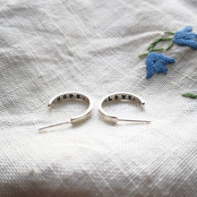 Load image into Gallery viewer, Mini eco silver hoops with hope and love messages inside, on fabric with blue flowers