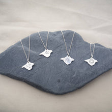 Load image into Gallery viewer, Isle of Wight silver necklaces displayed on grey stone, individual designs - birds, wave, textured and heart