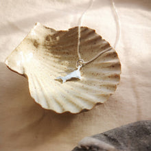 Load image into Gallery viewer, Mini Cornish silver pendant lying in ceramic stone ware shell dish in sunlight