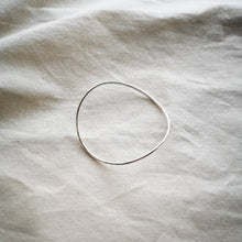 Load image into Gallery viewer, Minimalist curved silver bangle, on natural calico fabric