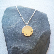 Load image into Gallery viewer, Initials L.A.T.A stamped on eco-silver coin necklace on slate background