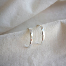 Load image into Gallery viewer, Hammered textured medium sized silver hoops on calico fabric
