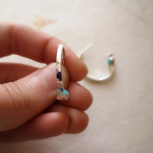 Load image into Gallery viewer, Hammered textured eco recycled silver hoops, handmade with secret gemstones, held by fingers to show texture