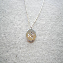 Load image into Gallery viewer, Oval eco silver coin necklace with three flying birds design and natural texture, reversible with stars on back