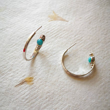 Load image into Gallery viewer, Textured eco silver hoop earrings with blue gemstones and silver balls inside hoop, on yellow and cream pressed flower paper
