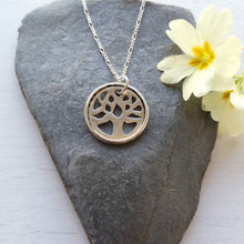 Load image into Gallery viewer, Recycled silver tree of life necklace, handmade with hidden message, on stone background with yellow primrose 
