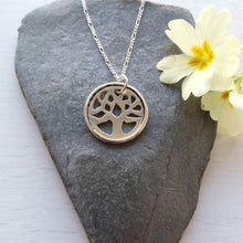 Load image into Gallery viewer, Recycled silver tree of life necklace, handmade with hidden message, on stone background with yellow primrose