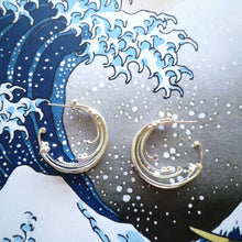 Load image into Gallery viewer, Ocean wave themed jewellery, eco recycled silver hoop earrings on background of The Great Wave Off Kanawaga ocean print