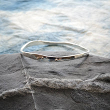 Load image into Gallery viewer, Handcrafted silver wave bangle, irregular natural wave shaped bangle with silver ball detail, on a grey stone and blue fabric