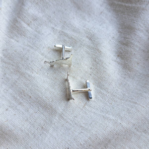 Handmade silver cornish map cufflinks on natural fabric