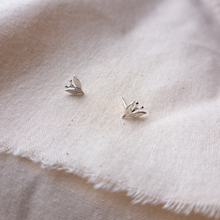 Load image into Gallery viewer, Silver leaf and berry stud earrings on plain natural calico fabric
