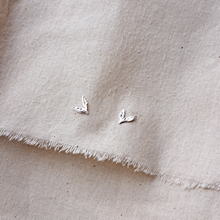 Load image into Gallery viewer, Silver leaf stud earrings on natural undyed cotton calico fabric

