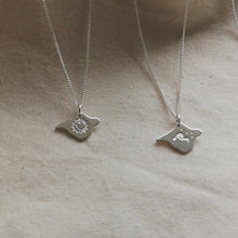 Load and play video in Gallery viewer, Video showing four silver Isle of Wight necklaces in turn, one with a heart design, one with a wave, one with birds and one textured
