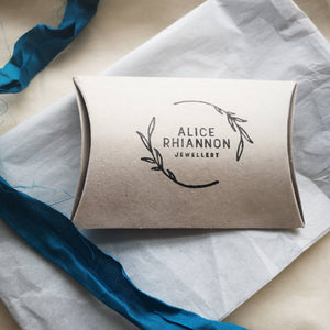 Alice Rhiannon Jewellery logo branded recycled card pillow box, with tissue paper and peacock blue ribbon