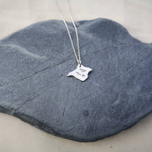 Load image into Gallery viewer, Silver Isle of Wight shaped necklace with three birds engraved, lying on a grey slate stone
