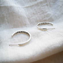 Load image into Gallery viewer, Silver medium sized hoop earrings with family and Teylu message inside (Teylu = cornish word for family)
