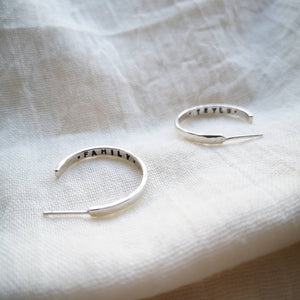 Silver medium sized hoop earrings with family and Teylu message inside (Teylu = cornish word for family)