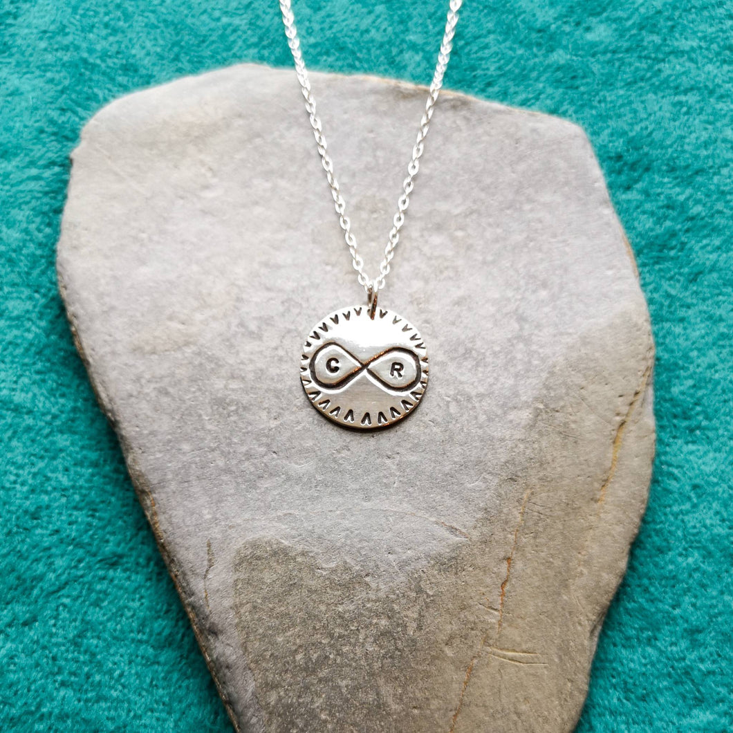 Personalised silver love token necklace, engraved with infinity symbol and personalised with initials 