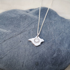 Heart with lines bursting out engraved on silver Isle of Wight shaped pendant on stone