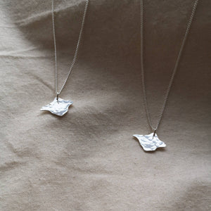 Two textured silver Isle of Wight handmade silver necklaces on natural calico fabric