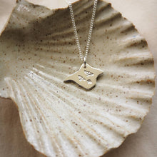 Load image into Gallery viewer, Three birds stamped on silver Isle of Wight shaped pendant, draped in a ceramic shell dish
