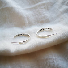 Load image into Gallery viewer, Medium sized silver hoops with love always secret message inside on white muslin fabric 
