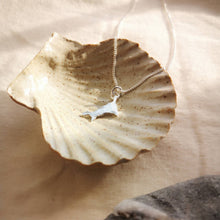 Load image into Gallery viewer, Mini Cornish silver pendant lying in ceramic stone ware shell dish in sunlight
