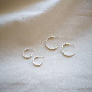 Medium and small set of four silver hoops on plain fabric
