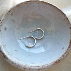 Mini silver hoop earrings side profile in light blue ceramic bowl, handmade in Cornwall
