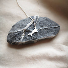 Load image into Gallery viewer, Mini Cornwall silver pendant on top of slate stone with quartz veins, on calico fabric background
