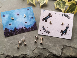 Tiny silver moon stud earrings on night sky forest and leaping foxes illustrated backing cards