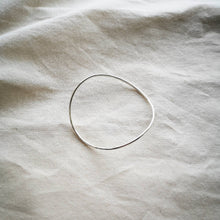 Load image into Gallery viewer, Minimalist curved silver bangle, on natural calico fabric 
