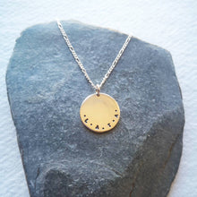 Load image into Gallery viewer, Initials L.A.T.A stamped on eco-silver coin necklace on slate background
