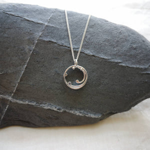 Mini recycled silver wave pendant, curved strands and silver ball details, hung from grey slate stone