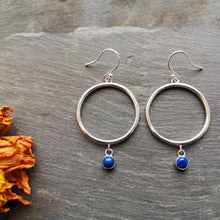 Load image into Gallery viewer, Recycled silver drop hoop earrings with deep blue lapis lazuli gemstones, on slate with orange dried flowers 
