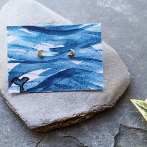 Half moon tiny eco silver studs on watercolour backing card of waves and a whale tail