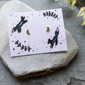 Recycled silver crescent moon studs on recycled cotton backing card with jumping foxes illustration