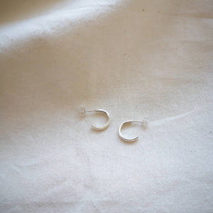 Simple mini silver hoops handmade in Cornwall, on plain calico fabric