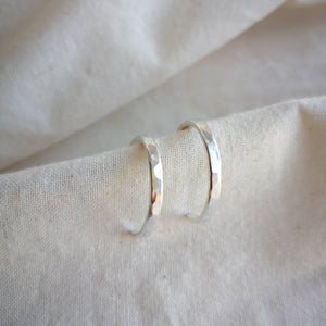 Hammered textured medium sized silver hoops on calico fabric
