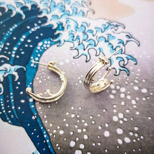 Unusual silver hoop earrings, wild wave ocean jewellery on background of wave splashing
