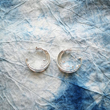 Load image into Gallery viewer, Sustainable recycled silver large wave hoop earrings, on tie dyed blue and white fabric
