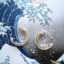 Load image into Gallery viewer, Ocean wave themed jewellery, eco recycled silver hoop earrings on background of The Great Wave Off Kanawaga ocean print
