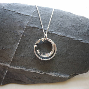 Handmade recycled silver cornish wave pendant, circular with strands and balls combining to suggest movement 